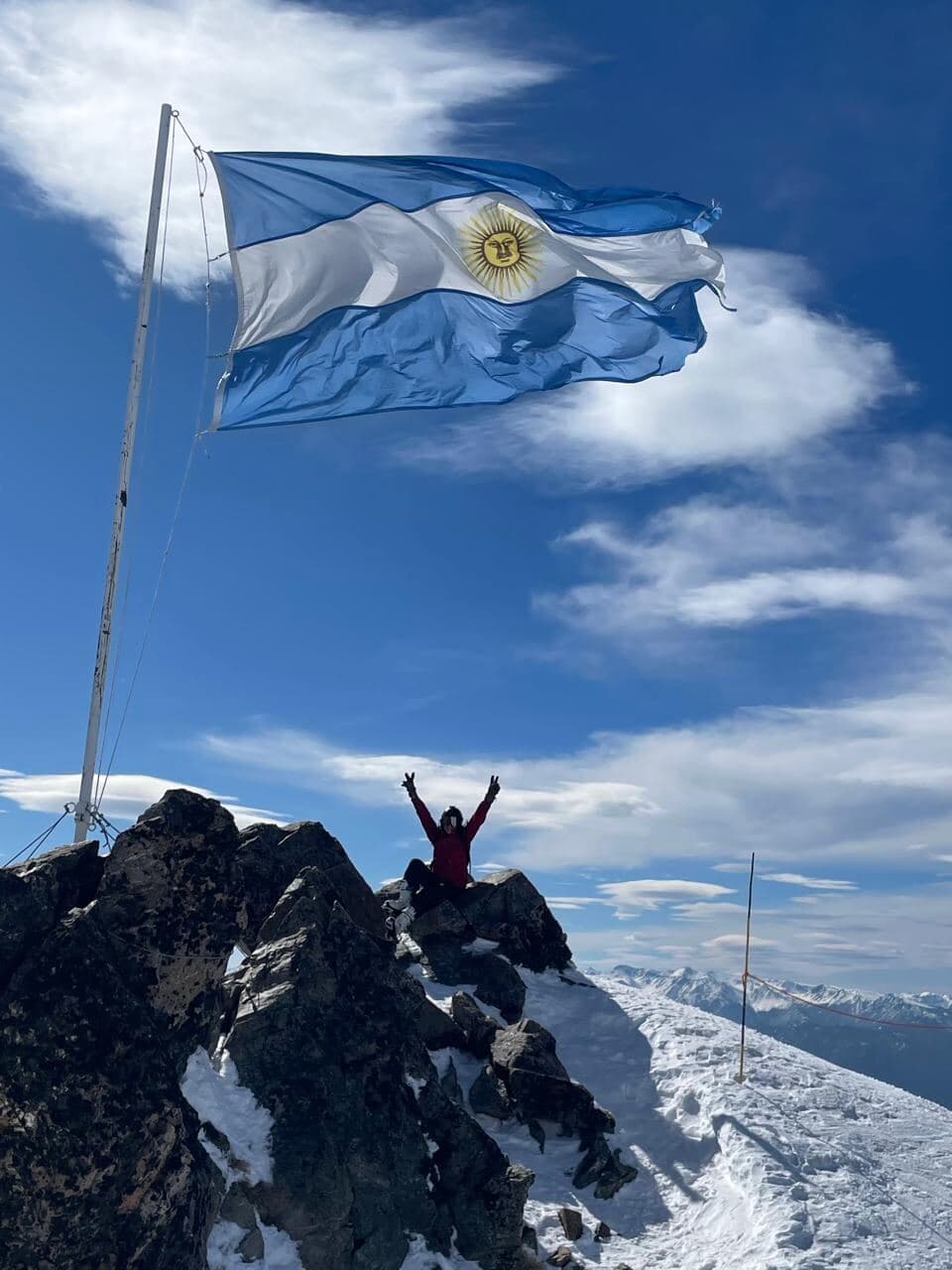 Argentine flag flying above snowy Patagonia peaks